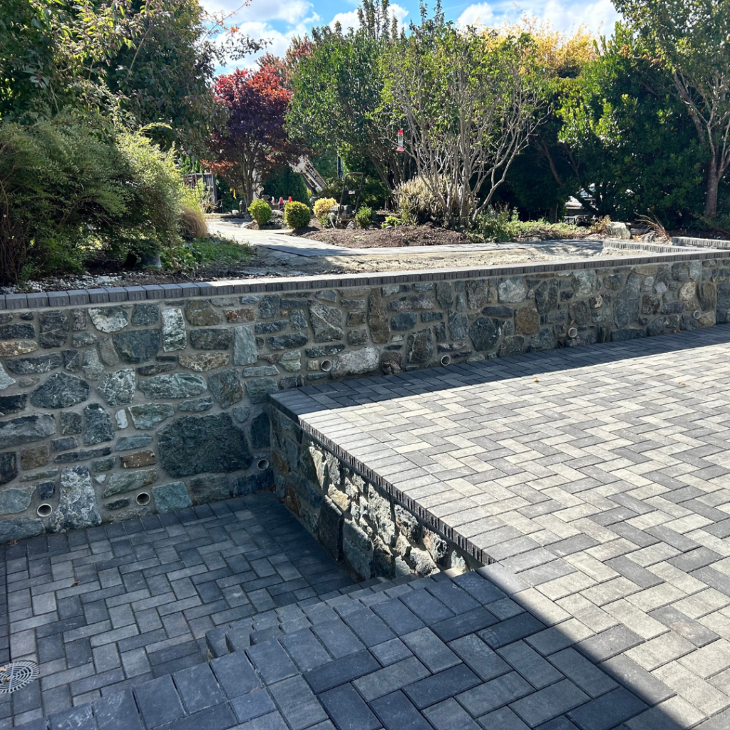 Rock wall bordering paver drive