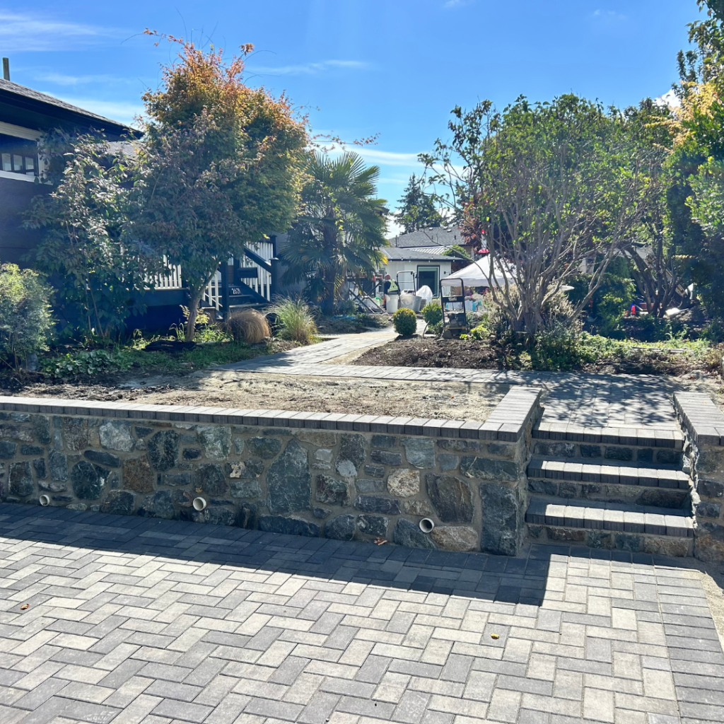 Roock wall and stairs along paver driveway
